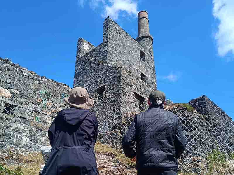 Two people looking at Allihies copper ine structure
