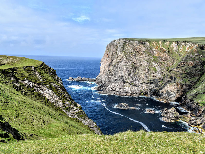 Green cliffs sloping into azure seas
