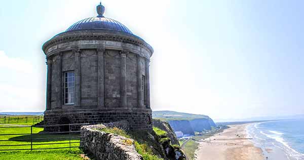 Round neoclassical temple on a cliff overlooking a beach