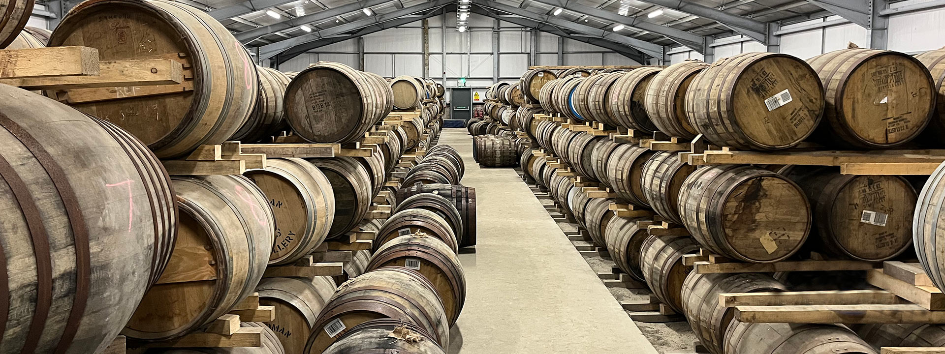 Rows of whiskey casks in a warehouse